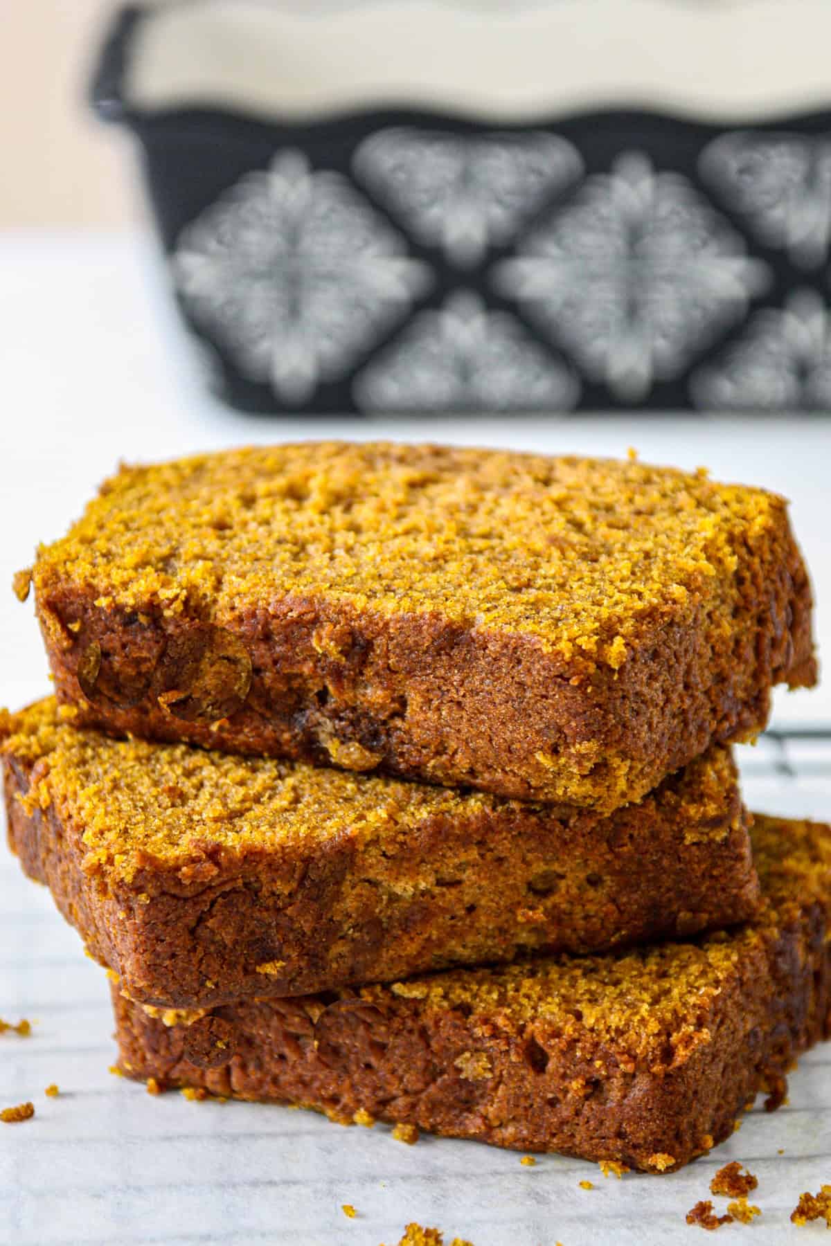 A stack of three slices of gluten free pumpkin bread.