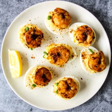 Cajun shrimp deviled eggs on a white plate.