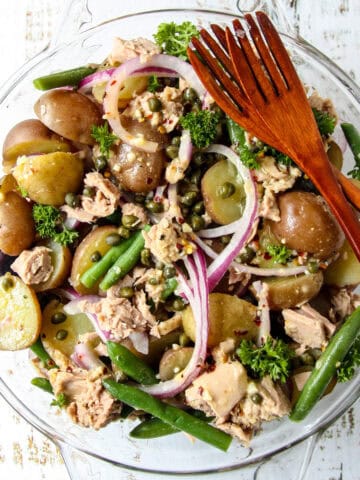 Tuna Potato Salad in a glass bowl with two wooden forks.